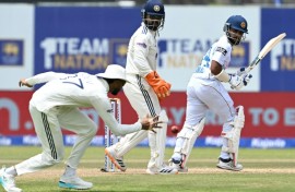 Sri Lanka's Sonal Dinusha (R) watches the ball after playing a shot during the third day of the first Test
