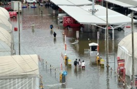 Pedestrians wade through flooded Bangkok roads after days of rain