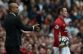 Former Manchester United striker Wayne Rooney (R) stands next to ex-Manchester City boss Pep Guardiola