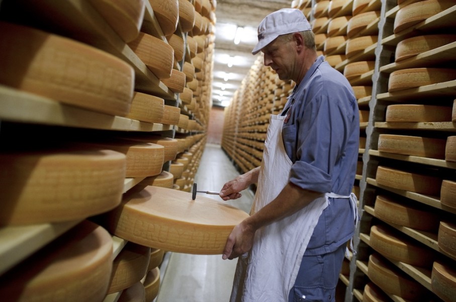 File: A Gruyere cheese wheel is checked during maturing operation in a giant cellar in Bulle, western Switzerland. AFP/Fabrice Coffrini