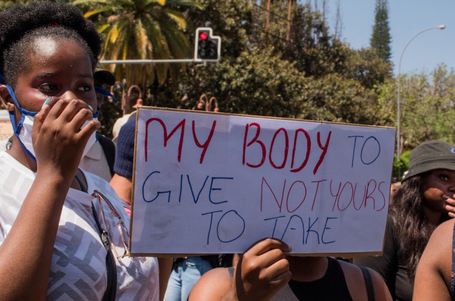 File: A protester holds a placard during a GBV protest.AFP/Hildegard Titus