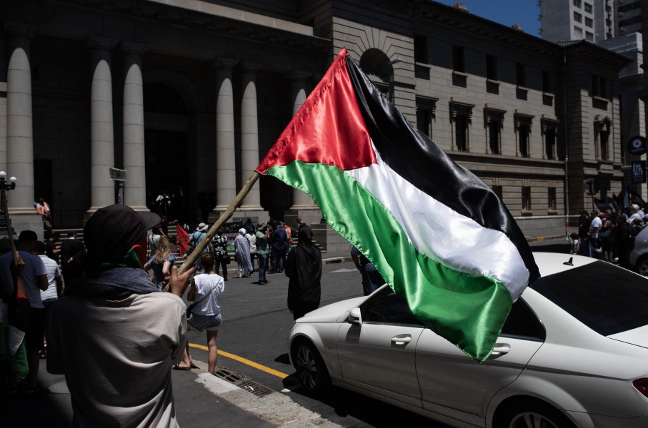 A man holds a Palestinian flag as they take part in a pro-Palestinian demonstration outside the High Court in Cape Town on January 11, 2024. Dozens of people took to the streets in Cape Town on on January 11, 2024 in one of several demonstrations planned across South Africa in support of the government’s landmark "genocide" case against Israel. 