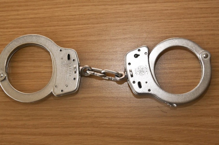File: A pair of handcuffs on a table. Rolf Kremming/dpa Picture-Alliance via AFP