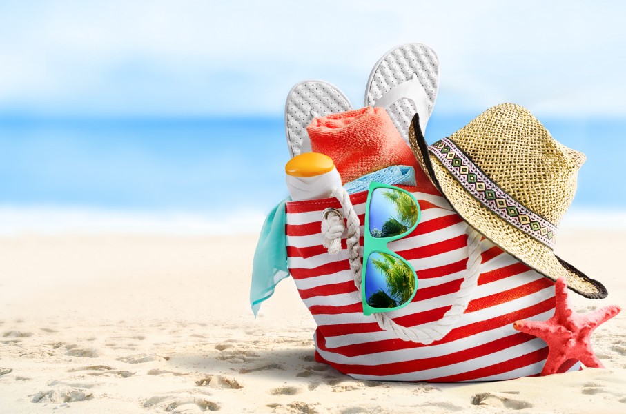 File: Beach bag, straw hat, flip flops, sunglasses and starfish on sandy beach. Getty Images/igoriss