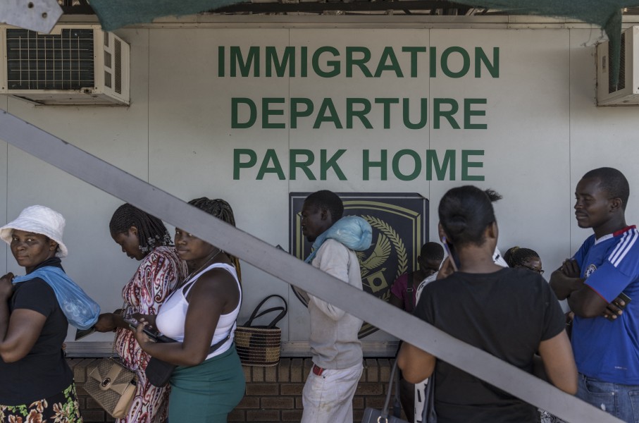 File: Zimbabwean migrants wishing to enter South Africa queue at a passport check before the immigration offices at the Beitbridge crossing. AFP/Marco Longari