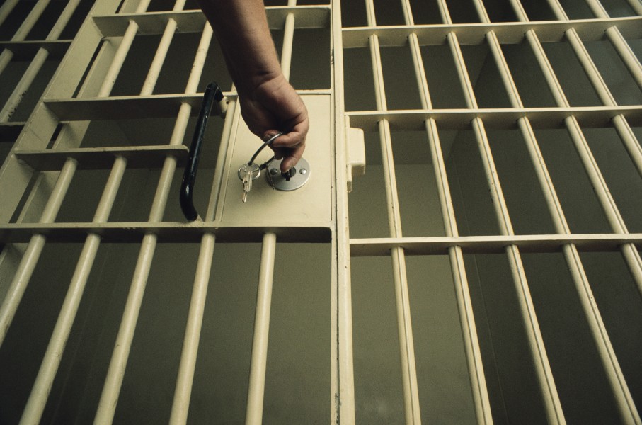 An officer locking a jail cell. GettyImages/Charles O'Rear