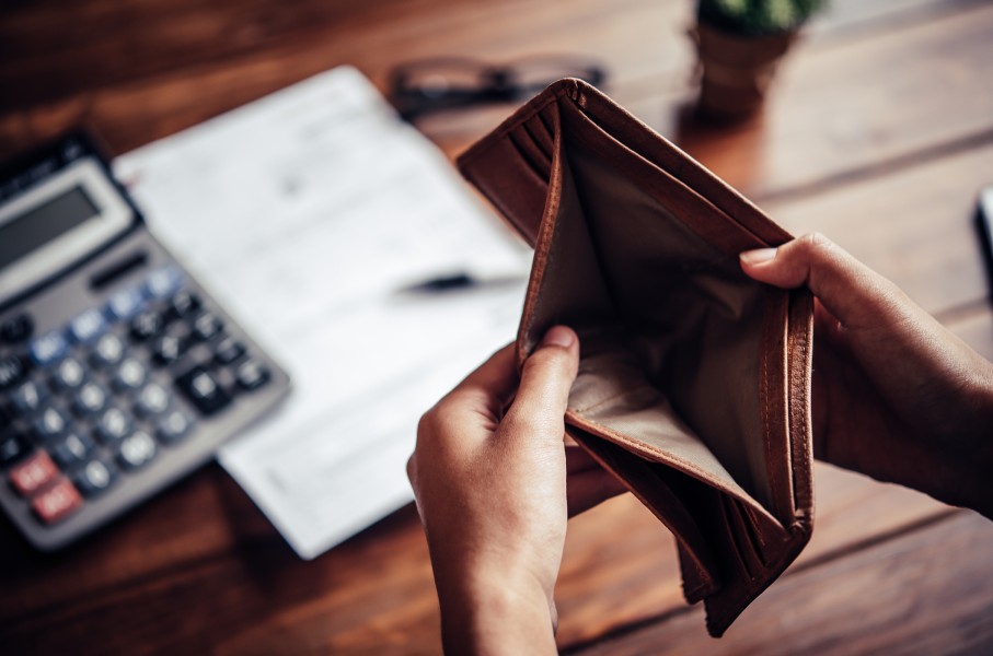 An empty wallet and calculator, budget. GettyImages/photobyphotoboy