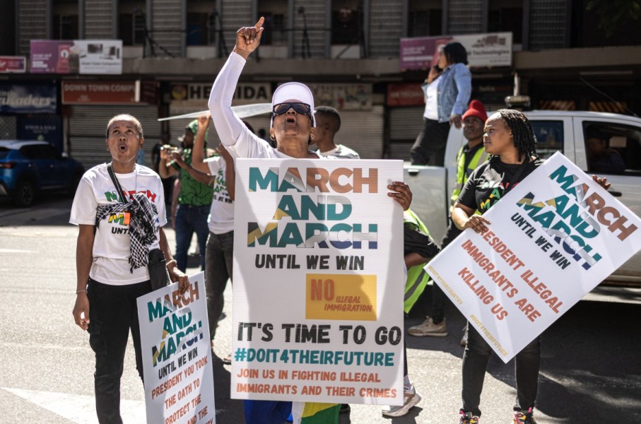Protesters chant slogans and hold placards at a protest march against undocumented migrants. AFP/Emmanuel Croset