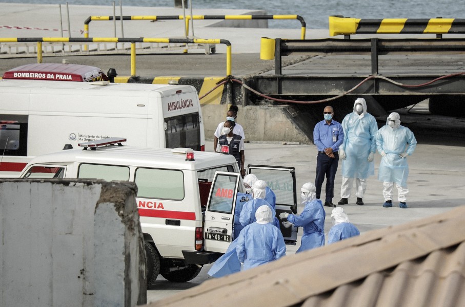 Health personnel returning from the cruise ship MV Hondius, are seen at the port of Praia, the capital of Cape Verde, as individuals wearing hazmat suits are helped into an ambulance on May 6, 2026.