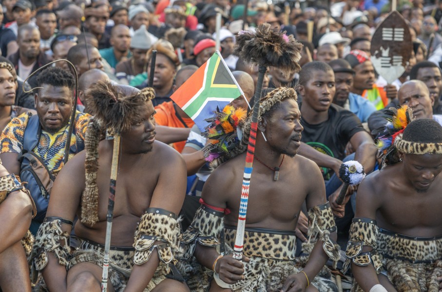 A South African flag is seen in a protester's head gear as he gathers with other protesters during a protest march against undocumented migrants in Durban on May 6, 2026.
