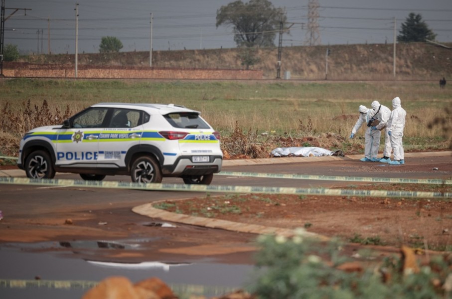 Members of the South African Police Service (SAPS) Forensic Pathology Services work on the crime scene where the body of a woman was discovered in Boksburg. AFP/Emmanuel Croset