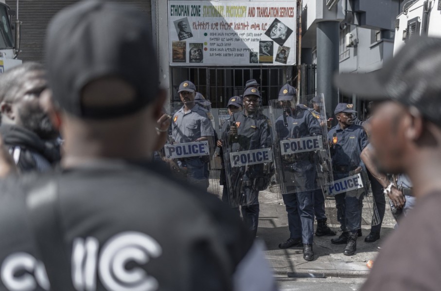Members of the South African Police Service (SAPS) keep watch outside of the Department of Home Affairs Refugee Reception Centre on Che Guevara Road in Durban. AFP/Rajesh Jantilal