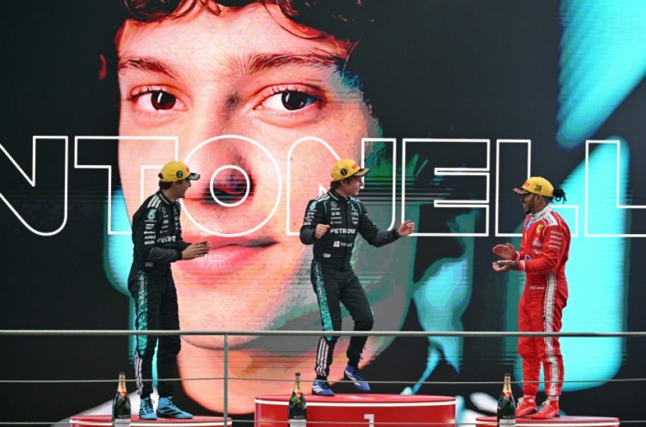 Winner Mercedes' Italian driver Kimi Antonelli (C), second-placed Mercedes' British driver George Russell (L) and third-placed Ferrari's British driver Lewis Hamilton (R) celebrate on the poidum after the Formula One Chinese Grand Prix at the Shanghai International Circuit in Shanghai on March 15, 2026.