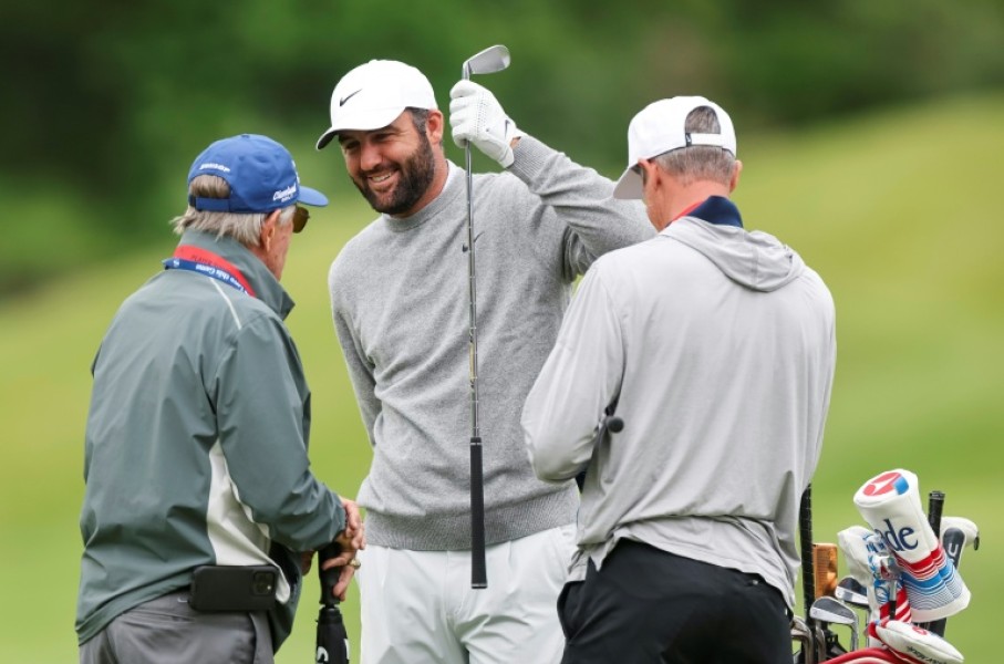 Top-ranked defending champion Scottie Scheffler, center, talks with caddie Ted Scott, right, and swing coach Randy Smith during a practice round at Aronimink ahead of the 108th PGA Championship