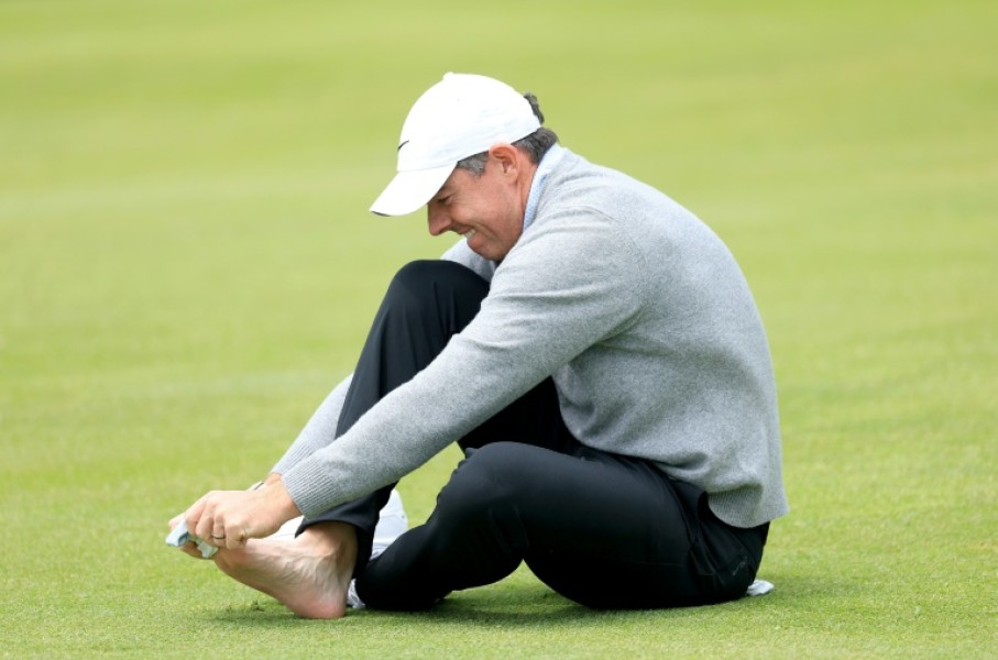 Second-ranked Rory McIlroy of Northern Ireland checks on a blister on his right pinky toe on the 18th hole during a practice round on the eve of the opening round of the PGA Championship at Aronimink