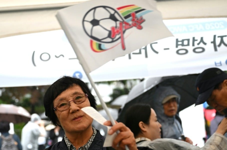 A South Korean football supporter waves a flag of North Korean team Naegohyang Women's FC
