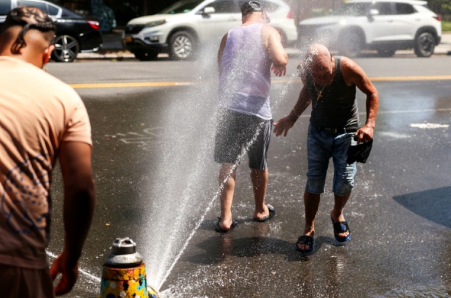 Men cool off at a fire hydrant in the Hamilton Heights neighborhood in Manhattan