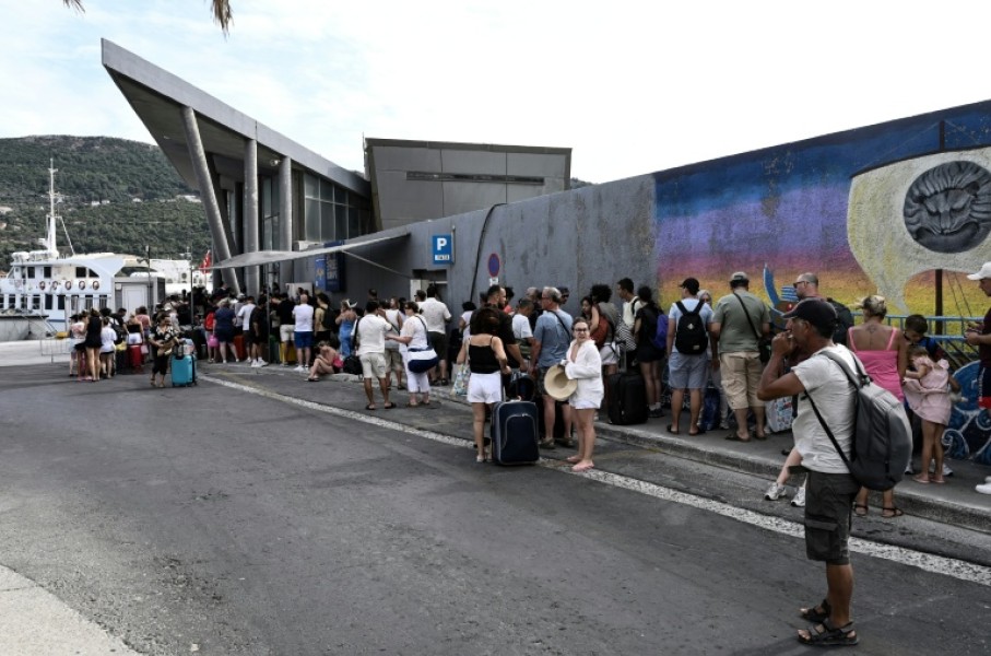 Visiting Turkish tourists line up to get their visa on arrival at the customs office in the village of Vathy on Greece's Samos island