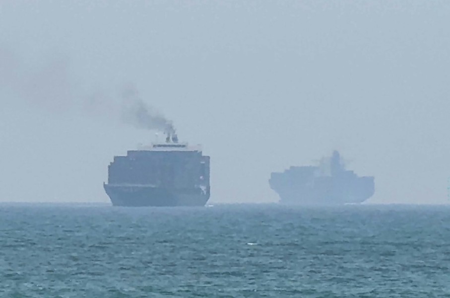 Cargo ships anchoring near the Strait of Hormuz off the eastern coast of the United Arab Emirates at Khor Fakkan