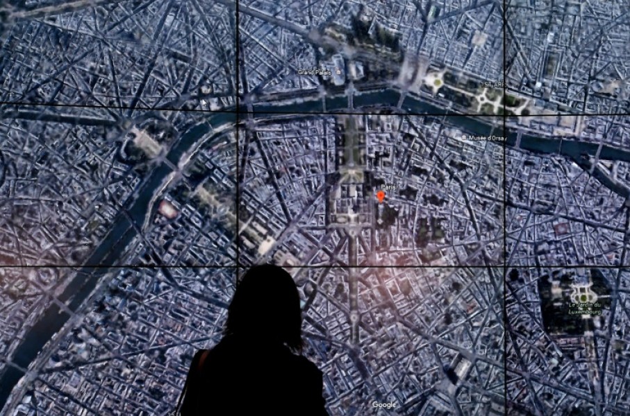 This April 18, 2017 file photo shows people viewing a Google Earth map of Paris, France at an event at New York's Whitney Museum of Art