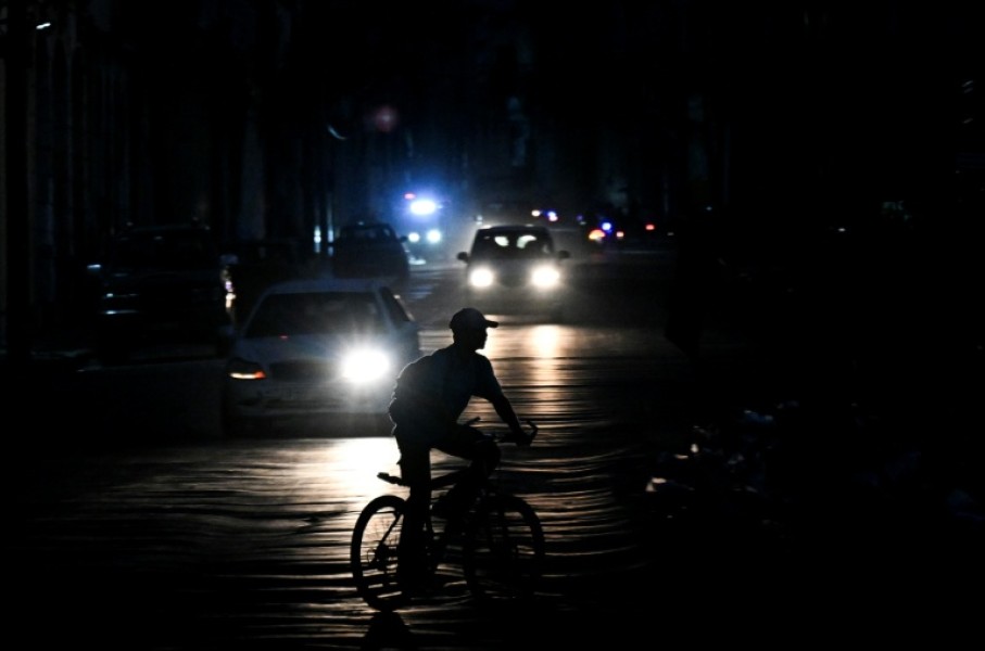 A man rides his bicycle down a street during a blackout in Havana