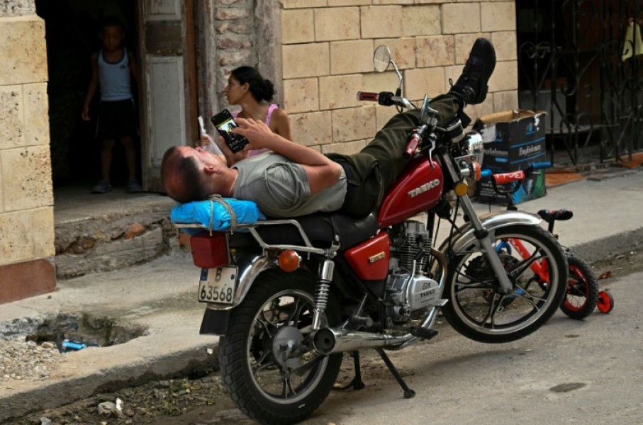 A man looks at his phone on a street during a blackout in Havana