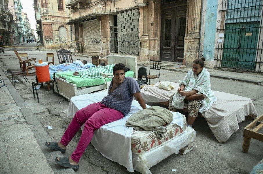Sleeping out in the stifling summer heat leaves residents of a partially collapsed building exhausted