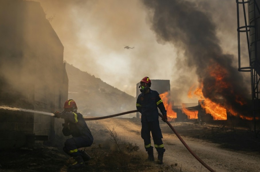 Firemen battling a blaze that broke out at a livestock facility near Kouvaras, south of Athens