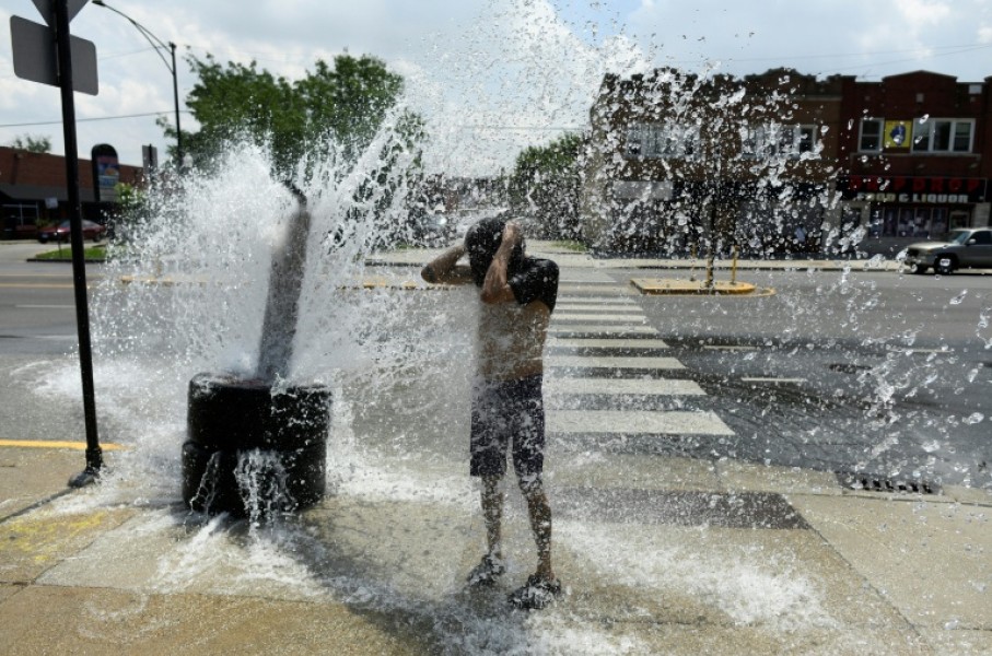 A person cools off with water from an open fire hydrant during a heat wave on the West Side of Chicago, Illinois, on July 2, 2026