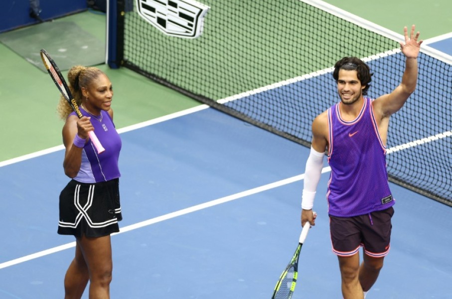 Serena Williams and Carlos Alcaraz salute the crowd after winning their mixed doubles opener at the US Open