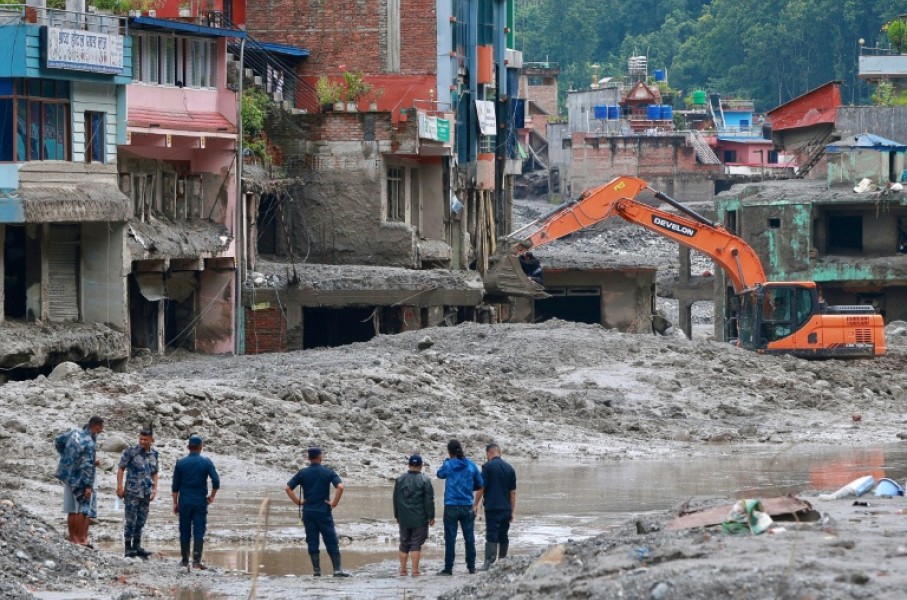 Workers use excavators to clear the mud at the Dhunge Bazaar in Nepal's Nuwakot district on August 29, 2026