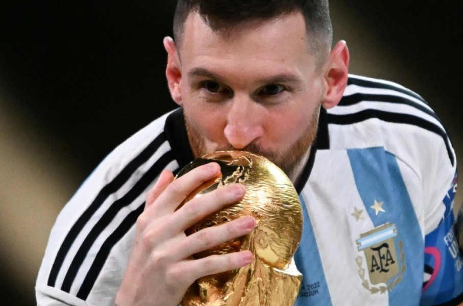 Lionel Messi kisses the World Cup trophy after winning the 2022 final against France in Doha