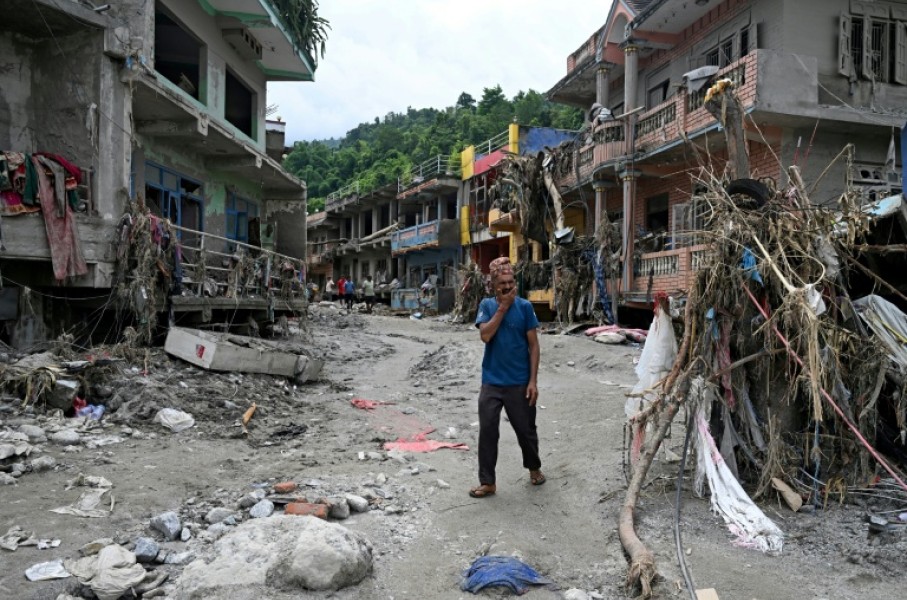 A man walks past damaged houses following flash floods at Devighat in Nepal's Nuwakot district on August 31, 2026