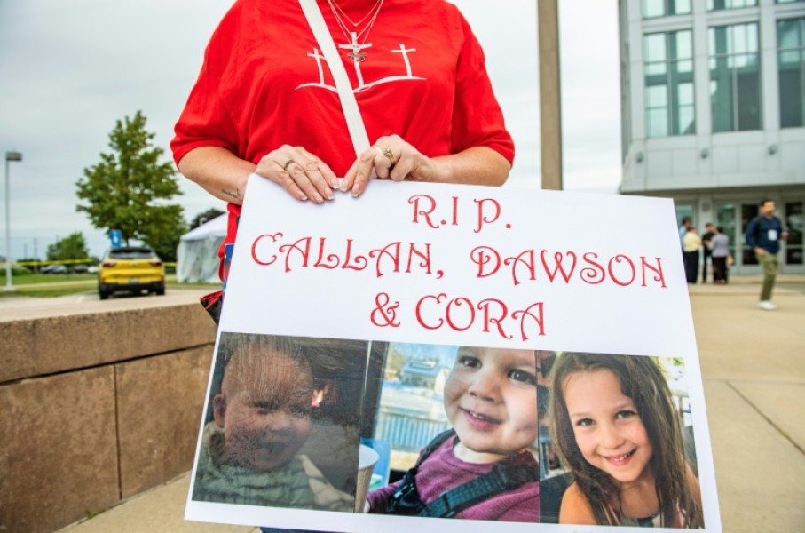 A woman carries a sign to show support for the three children of Lindsay Clancy during her murder trial in Plymouth, Massachusetts