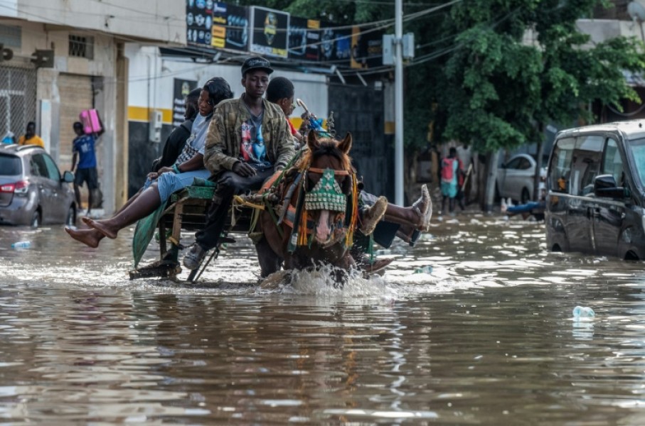 A horse cart transports passengers through a flooded street in Dakar, on October 5, 2026
