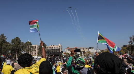 South Africans fly flags as they look at a flypast during President Cyril Ramaphosa's inauguration. AFP/Phill Magakoe