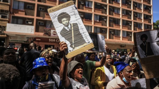A protester holds a placard with Isaac Satlat's picture. Gallo Images/Phill Magakoe