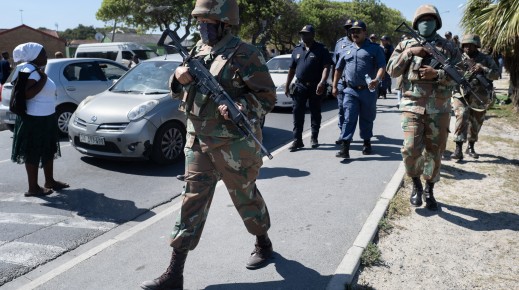 South African National Defence Force (SANDF) soldiers walk with South African Police Service (SAPS) officers in Mfuleni township in Cape Town on March 31, 2026.