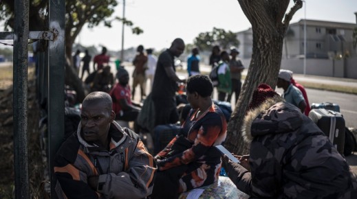 Malawian undocumented migrants sit in a shaded area in Durban. AFP/Marco Longari
