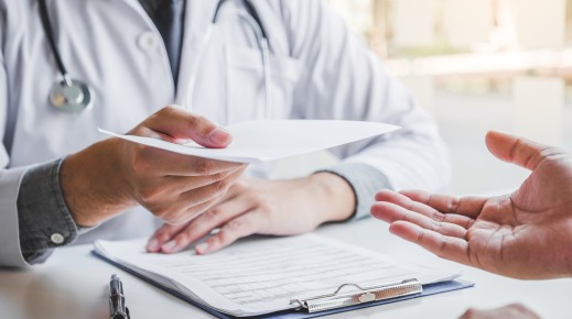  Doctor or physician writing diagnosis and giving a medical prescription to male Patient. Getty Images SARINYAPINNGAM