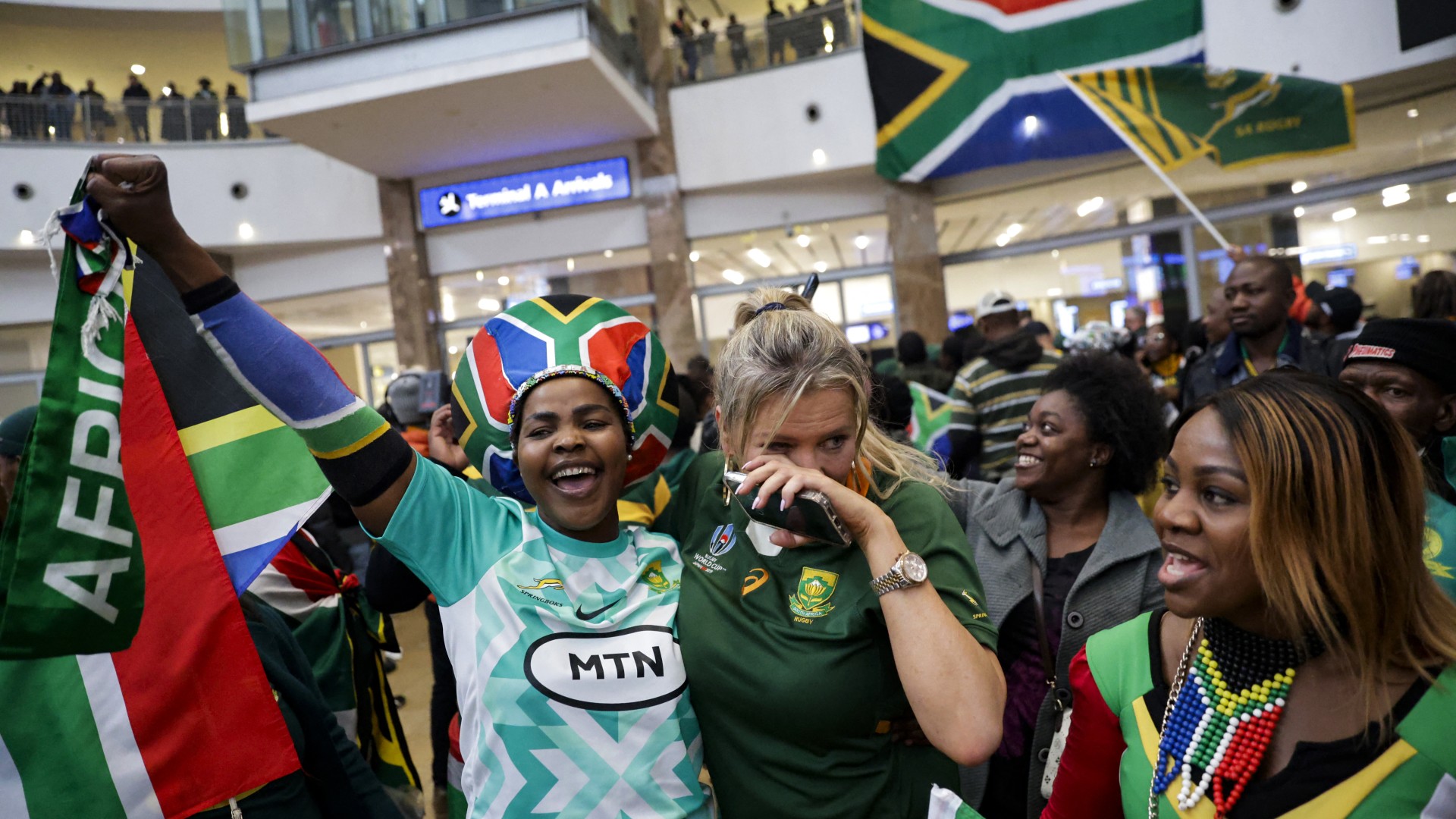 Supporters react ahead of the South African rugby team's arrival at the OR Tambo International airport in Ekurhuleni on October 31, 2023, after they won the France 2023 Rugby World Cup final match against New Zealand.