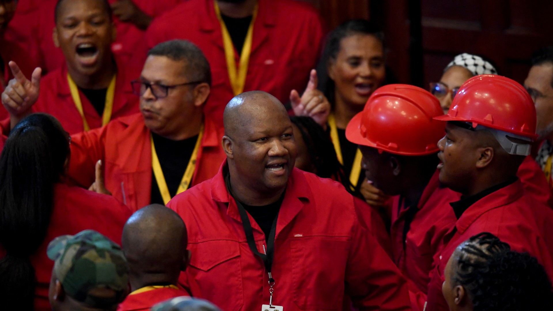 Members of the Economic Freedom Fighters (EFF), wearing their signature red overalls, sing as they arrive at the Cape Town City Hall. AFP/Rodger Bosch