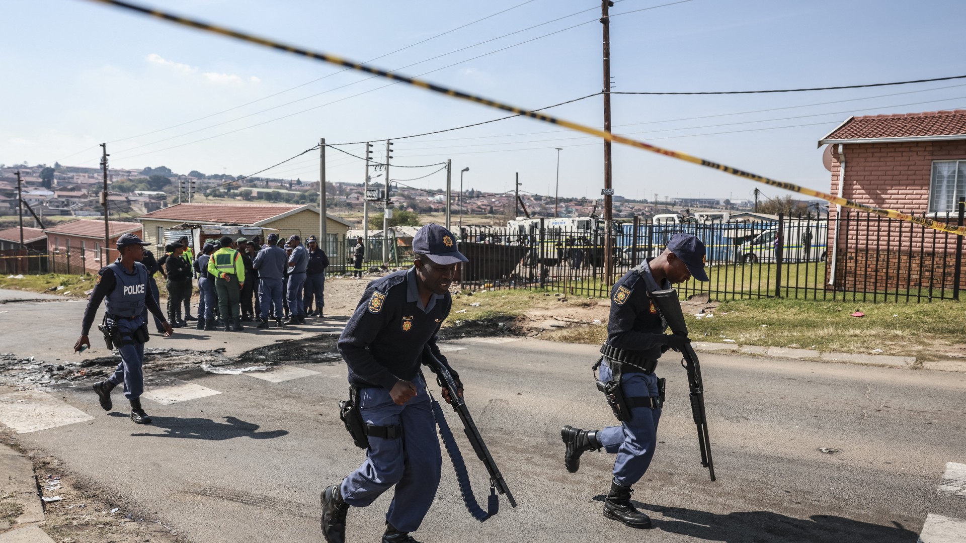 South African Police Service (SAPS) officers leave the scene where an alleged protestor died following a demonstration at Diepkloof Hostel in Soweto on May 19, 2025.