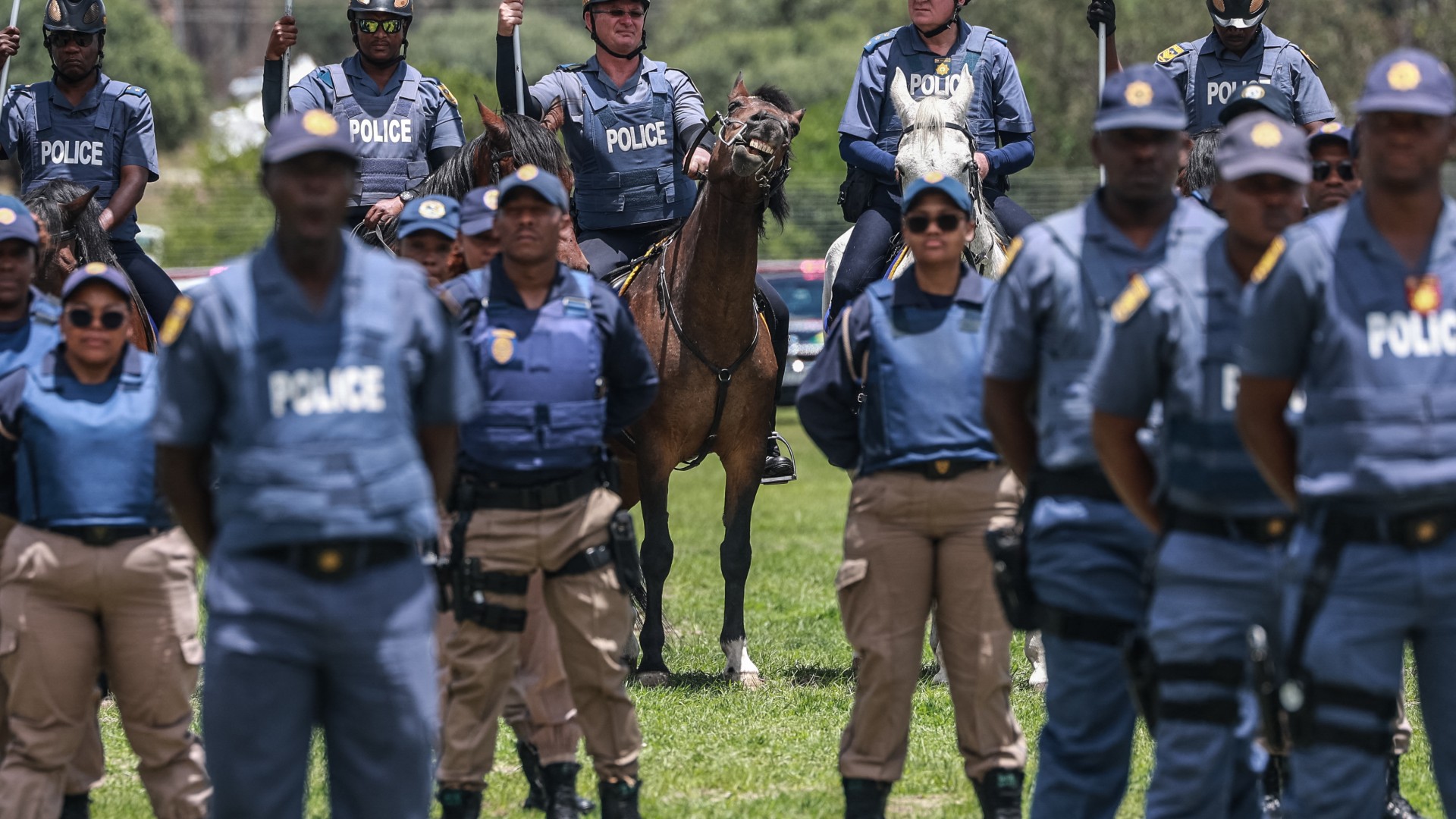 Members of the South African Police Service (SAPS) Mounted Unit stand at attention during the Integrated Law Enforcement parade near the Nasrec Expo Centre in Johannesburg, on November 19, 2025.