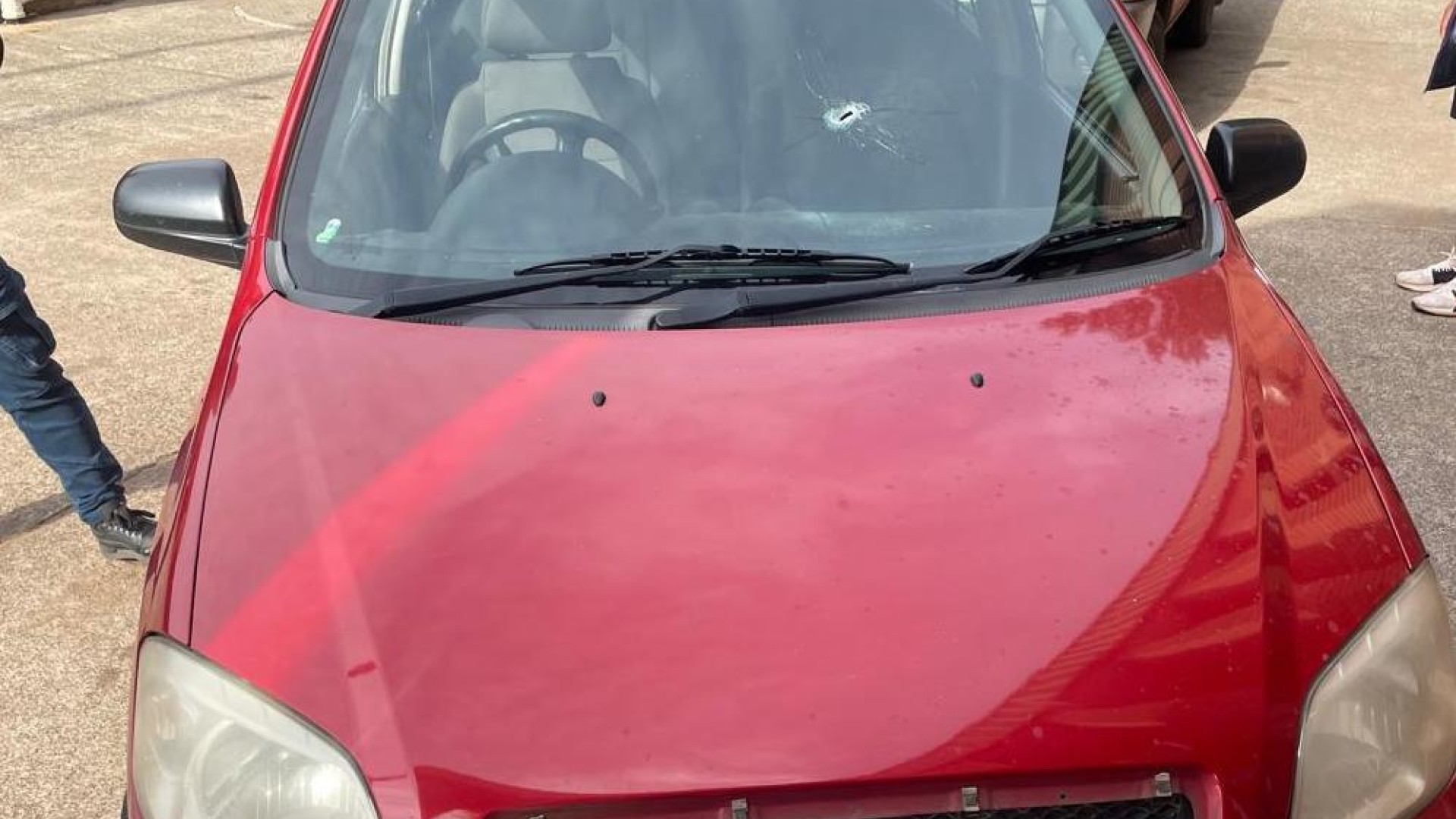 A red Chevrolet Aveo sedan, with a bullet hole in the windscreen, belonging to Brown Mogotsi