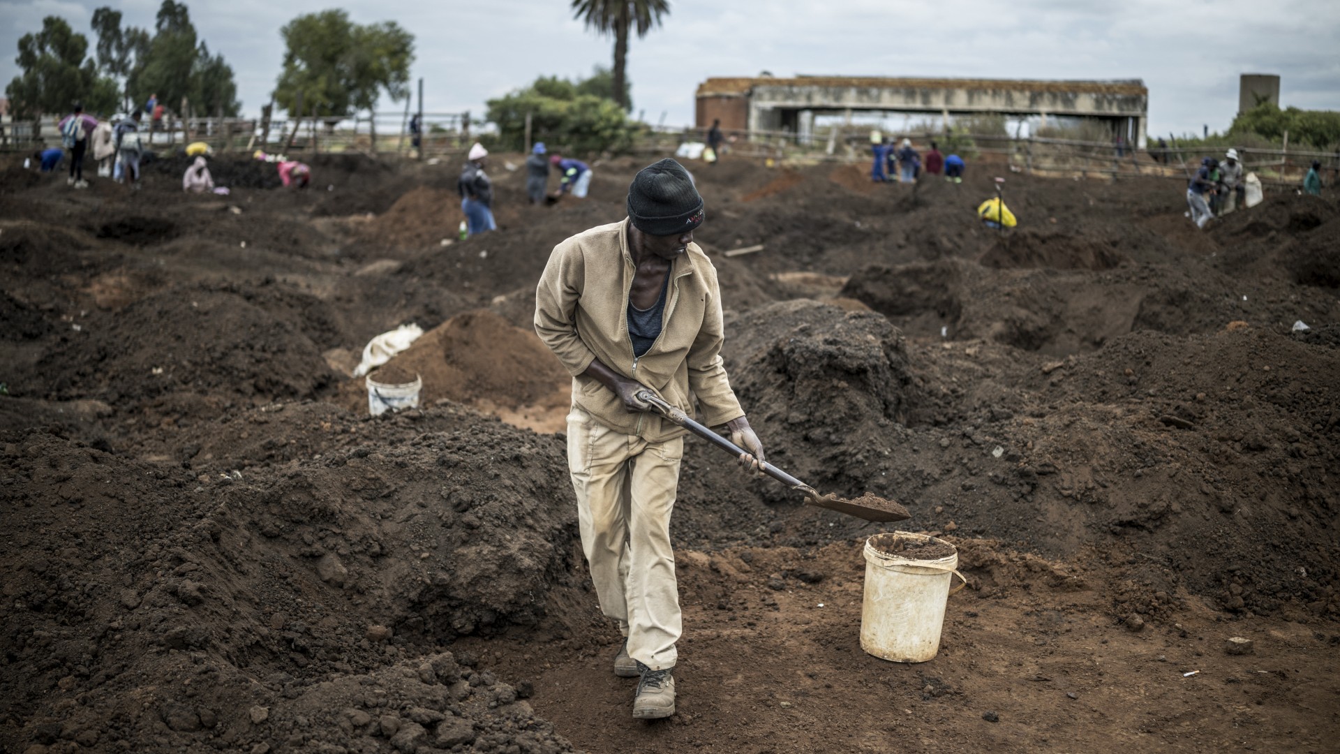 A man digs using a spade in a patch of land where artisanal miners look for gold outside Springs, Ekurhuleni, on February 15, 2026.