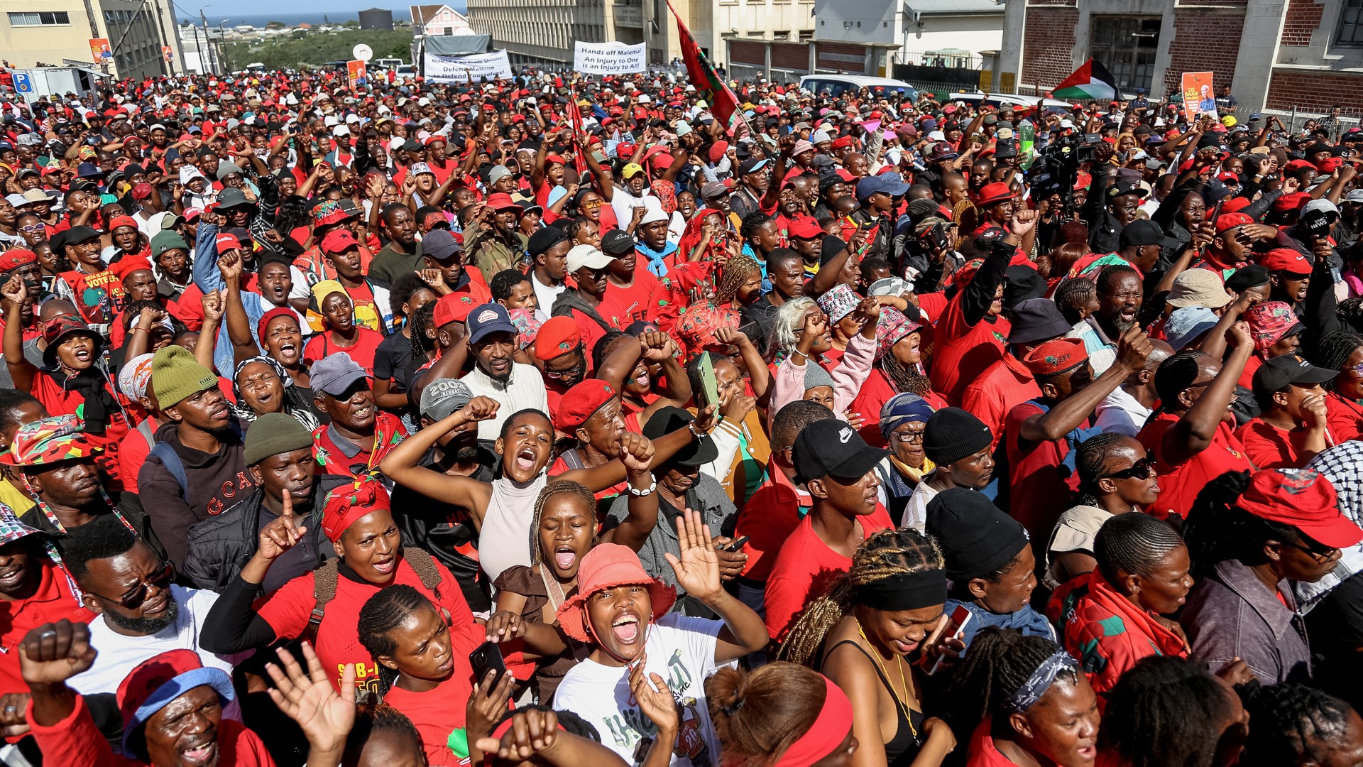 Supporters of Economic Freedom Fighters (EFF) leader Julius Malema listen to his speech outside the KuGompo City Regional court in East London on April 15, 2026 following his sentencing for firing an assault rifle at a rally eight years ago.