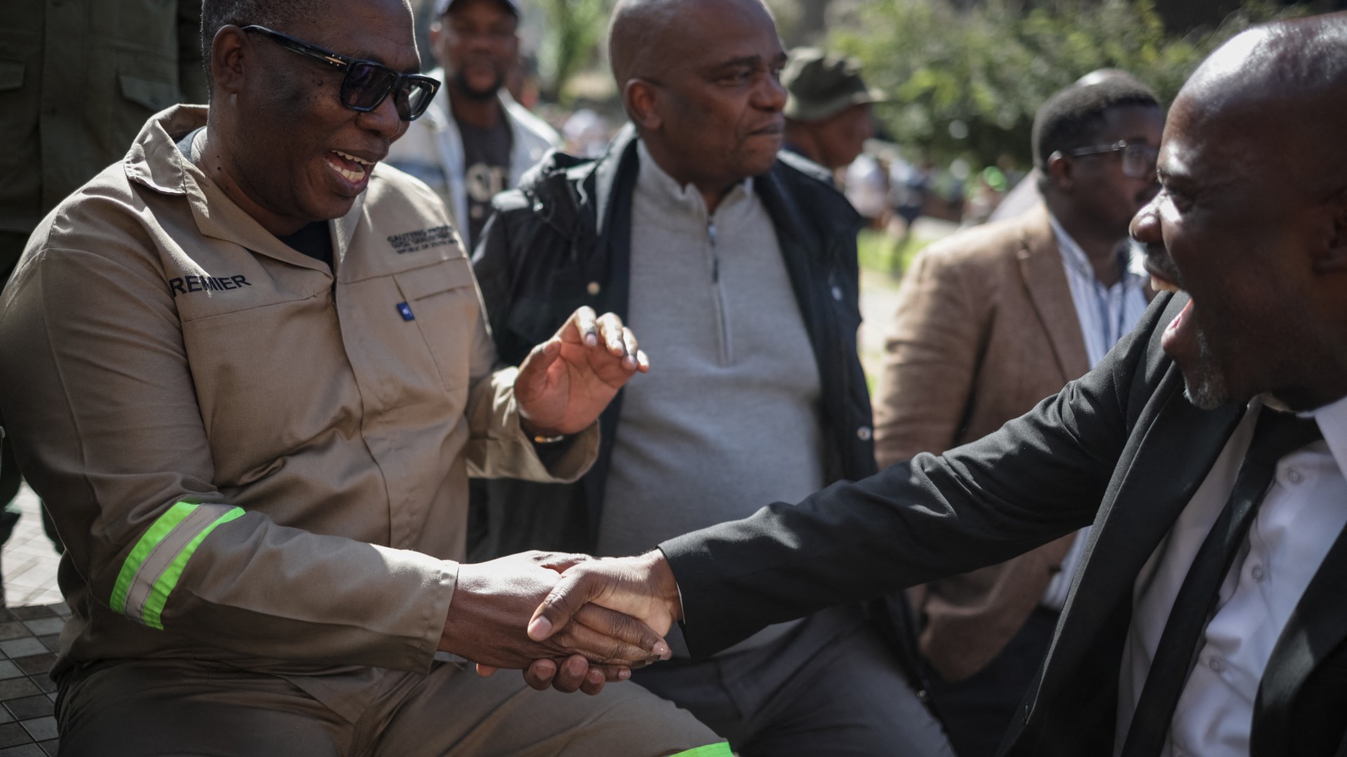 South Africa's Gauteng Province Premier Panyaza Lesufi (L) shakes hands with Evangelist Sipho Trevor Dlamini (R) before protesters handed him a memorandum during a protest march against undocumented migrants organised by “March and March” in Johannesburg on April 29, 2026.