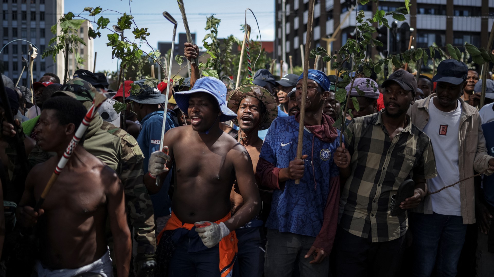 Protestors hold branches and sticks during a protest march against undocumented migrants organised by “March and March” in Johannesburg on April 29, 2026.