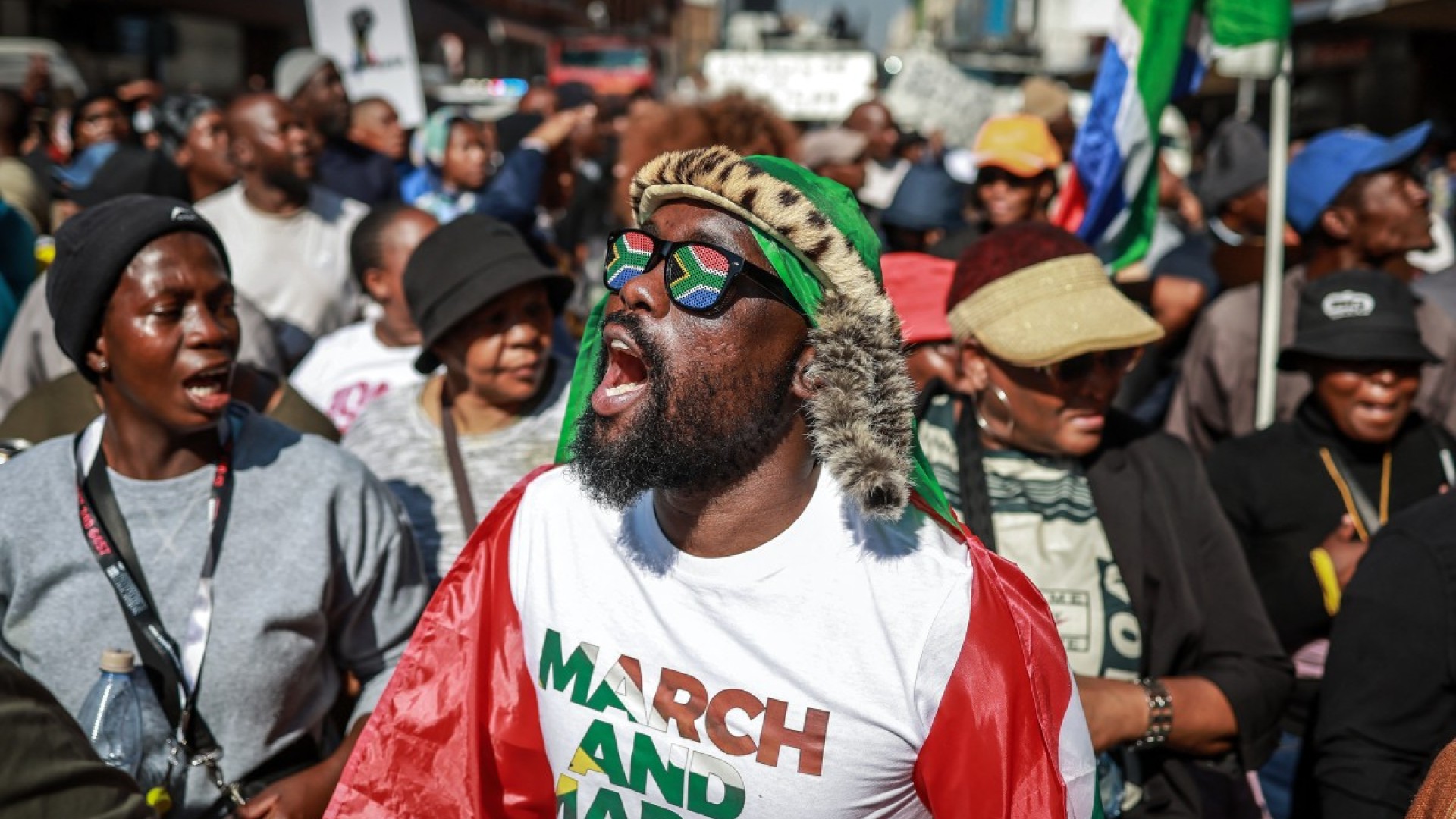 Protesters chant slogans as they march during a demonstration by the "March and March" and Operation Dudula movements. AFP/Phill Magakoe